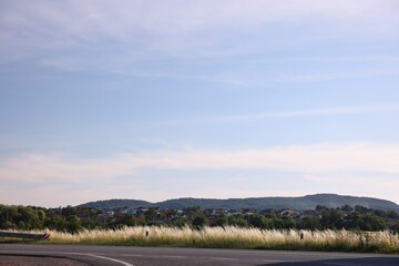 View of mountain, village and road under blue sky