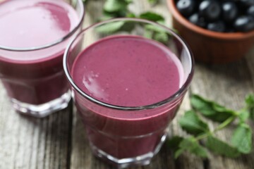 Tasty fresh acai juice in glasses on table, closeup