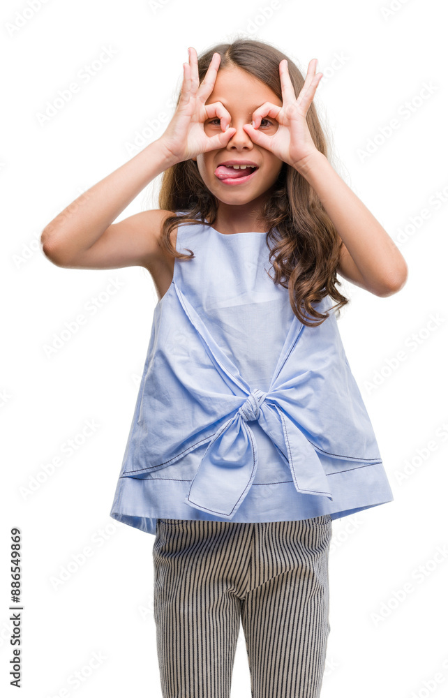 Wall mural brunette hispanic girl doing ok gesture like binoculars sticking tongue out, eyes looking through fi