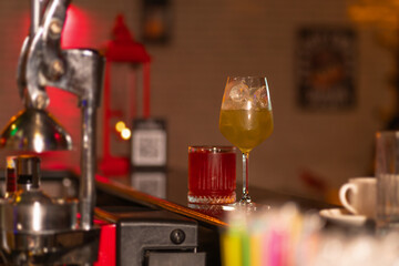 Close-up of a half-glass with a cocktail and ice on the bar. Concept of making cocktails
