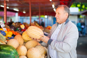 Middle aged man buying melon