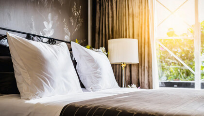 Bed maid-up with clean white pillows and bed sheets in beauty room. Close-up. Lens flair in sunlight,image