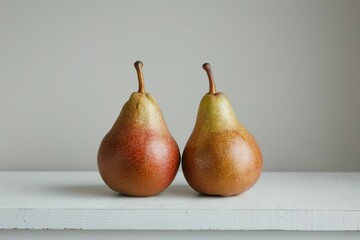 Two Ripe Pears on a White Shelf