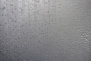 Water droplets on raining day with dark cover background. Water droplets concept