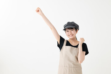 ガッツポーズをするエプロン姿の女性