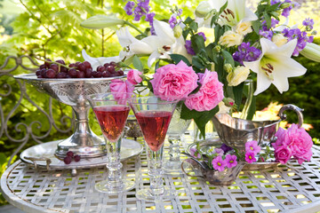 Wine and roses still life on a table outdoors