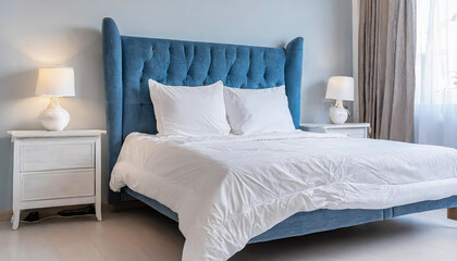 interior with white bed linen on the sofa bedroom with bed white bedding and bedside table white pillows duvet and duvet case on bed with blue headboard front view