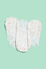 Smears of body scrub on green background. Fruit and berry body scrub texture of the swatch. Cosmetic smear