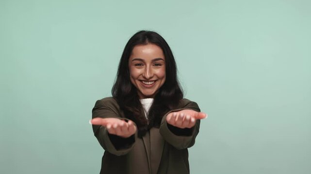 An unrecognizable woman extending her hands forward in a welcoming, inviting gesture against a turquoise background.