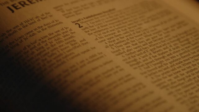 Bible text in soft candle light, candle is burning nearby, one page of printed holy scripture, Close up, High quality 4k footage