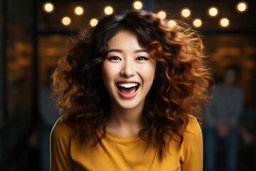 Asian girl laughing in yellow sweater with loose wavy hair