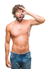 Fototapeta premium Handsome hispanic model man sexy and shirtless over isolated background doing ok gesture shocked with surprised face, eye looking through fingers. Unbelieving expression.