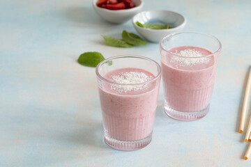 Healthy summer strawberry smoothie with yogurt and coconut, wheat drinking straw