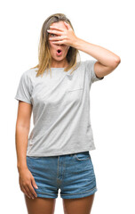 Fototapeta premium Young beautiful woman over isolated background peeking in shock covering face and eyes with hand, looking through fingers with embarrassed expression.