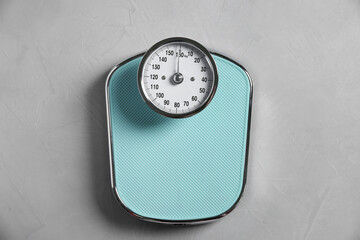 One bathroom scale on grey textured background, top view