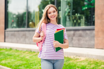 Photo of adorable sweet lady wear striped t-shirt school bag holding textbooks enjoying walking...