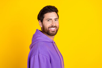 Portrait of good mood satisfied man with stylish bristle dressed purple hoodie smiling at camera isolated on yellow color background