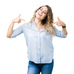 Beautiful young blonde business woman over isolated background looking confident with smile on face, pointing oneself with fingers proud and happy.