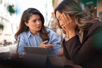 Young woman consoling and comforting upset and depressed Asian female friend