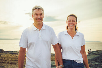 Obraz premium Happy Romantic Mature Couple Enjoying Sunset on the Beach