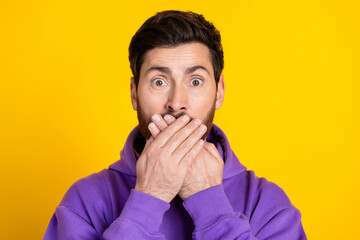 Portrait of speechless man with stylish bristle dressed purple hoodie hold hand on mouth staring...