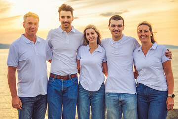 Fototapeta premium big family at beach on summer time, relax and support. Sunset, nature and smile with parents, kids walking by the sea for vacation