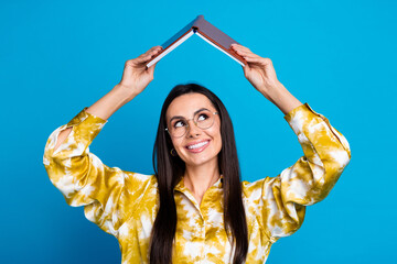 Photo of cheerful lovely latin woman wear trendy clothes hold book above head look empty space...