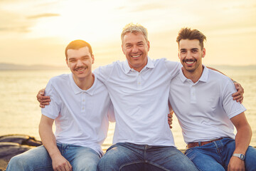 family at beach on summer time, father and is two son having fun