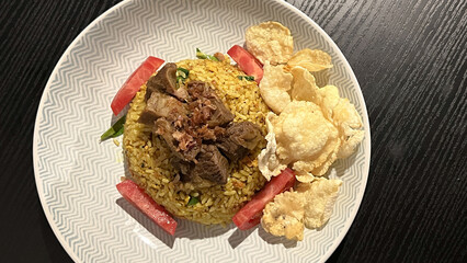 Arabian fried rice cooked with fried lamb, rice, garlic, tomatoes, and emping melinjo crackers