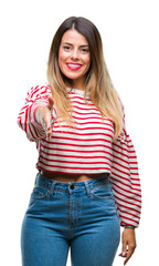 Young beautiful woman casual stripes winter sweater over isolated background smiling friendly offering handshake as greeting and welcoming. Successful business.