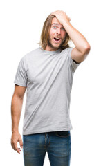 Young handsome man with long hair over isolated background surprised with hand on head for mistake, remember error. Forgot, bad memory concept.