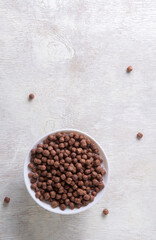 Milk in a glass and chocolate balls on a light background.