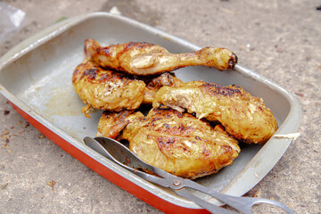 Juicy and seasoned pieces of chicken after grilling over charcoal. A delicious barbecue made outdoors.