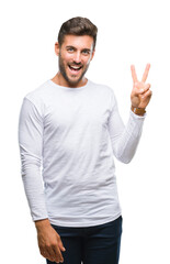 Young handsome man over isolated background smiling with happy face winking at the camera doing victory sign. Number two.