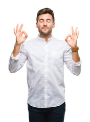Fototapeta premium Young handsome man over isolated background relax and smiling with eyes closed doing meditation gesture with fingers. Yoga concept.