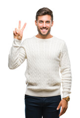 Naklejka premium Young handsome man wearing winter sweater over isolated background showing and pointing up with fingers number two while smiling confident and happy.