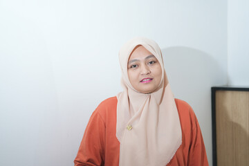 Fototapeta premium Portrait of a beautiful young Asian Muslim woman wearing a hijab being photographed in a studio