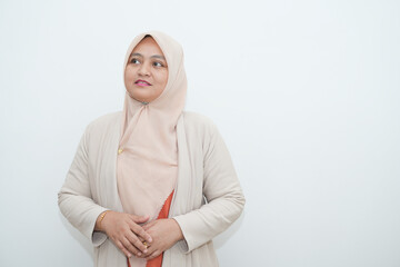 Fototapeta premium Portrait of a beautiful young Asian Muslim woman wearing a hijab being photographed in a studio