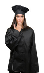 Young hispanic cook woman wearing chef uniform cover mouth with hand shocked with shame for mistake, expression of fear, scared in silence, secret concept