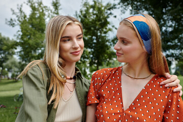 Obraz premium Two young women are enjoying a date in a park, looking lovingly at each other.