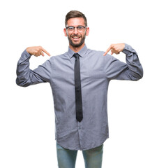 Young handsome business man over isolated background looking confident with smile on face, pointing oneself with fingers proud and happy.