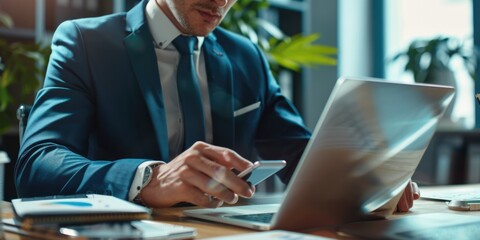 A person sitting at a desk with a laptop and cell phone, possibly working or browsing