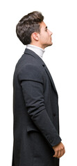 Young elegant man wearing winter coat over isolated background looking to side, relax profile pose with natural face with confident smile.