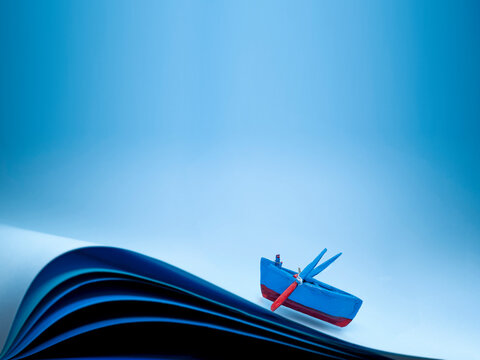 Conceptual empty rowing boat sailing in rough seas