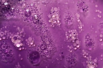 Bright purple liquid as background, top view