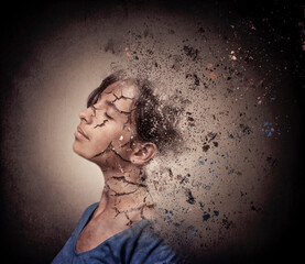 Portrait of a teenage girl with cracked skin breaking into a thousand particles of dust like a desert landscape