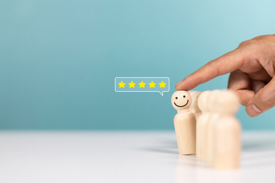 Service rating,winner,satisfaction and positive feedback concept. Customer choose smile face emoticon on a wooden figurines indicates satisfaction for the five star rating