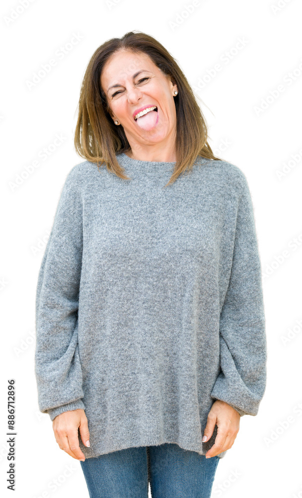 Canvas Prints beautiful middle age woman wearing winter sweater over isolated background sticking tongue out happy