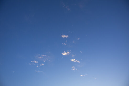 A clear blue sky with a few small white clouds