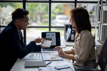 A man and a woman are sitting at a desk with a presentation in front of them